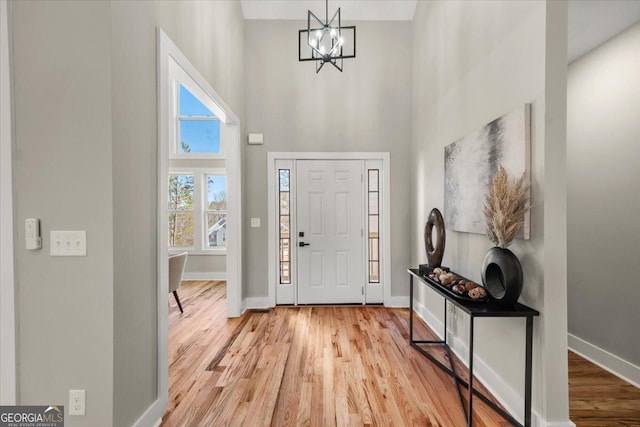 foyer entrance with baseboards and wood finished floors