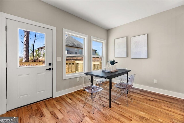 dining space featuring light wood-type flooring and baseboards