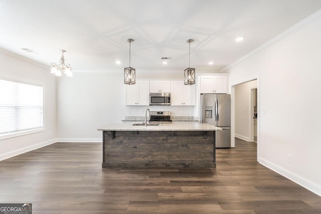 kitchen featuring visible vents, appliances with stainless steel finishes, a kitchen island with sink, white cabinetry, and a sink