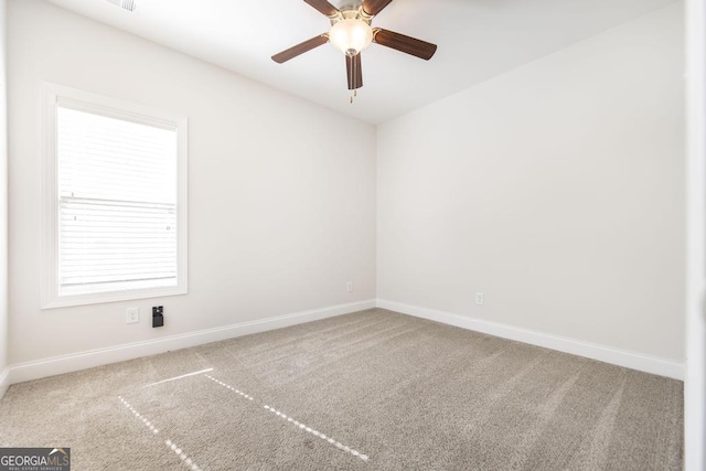 spare room with a ceiling fan, baseboards, and carpet flooring