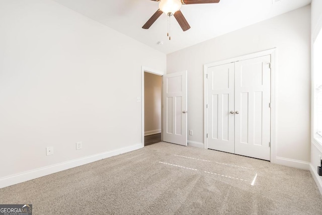 unfurnished bedroom with carpet floors, ceiling fan, baseboards, and a closet