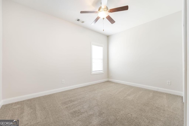 unfurnished room with baseboards, visible vents, and light colored carpet