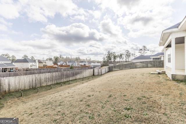 view of yard featuring a fenced backyard and a residential view