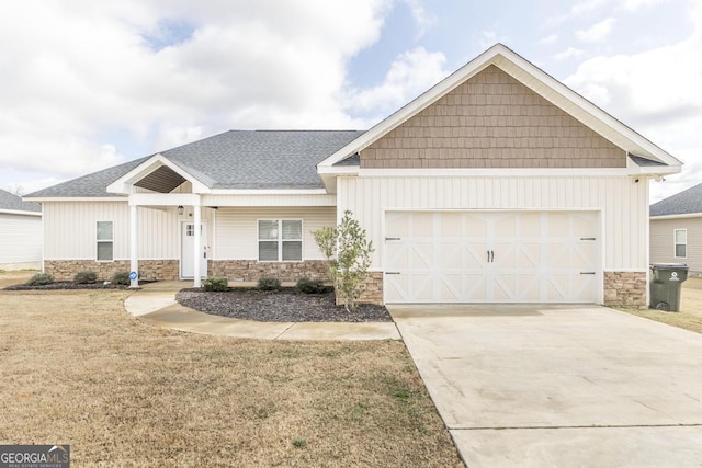 craftsman inspired home with stone siding, concrete driveway, an attached garage, and a front yard