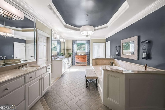 full bathroom with a tray ceiling, two vanities, ornamental molding, a sink, and a tub