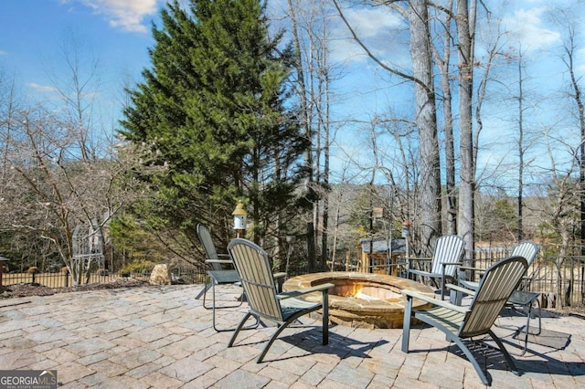 view of patio featuring an outdoor fire pit and fence