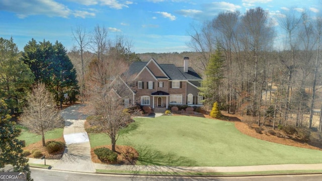 view of front of property featuring a chimney and a front yard