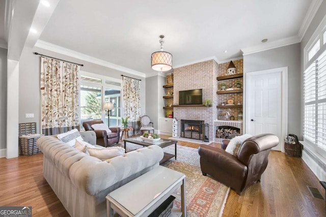 living area with a healthy amount of sunlight, visible vents, and wood finished floors