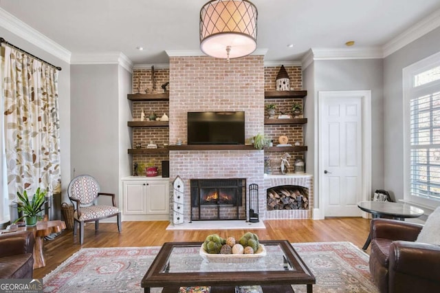 living area with ornamental molding, a fireplace, and wood finished floors