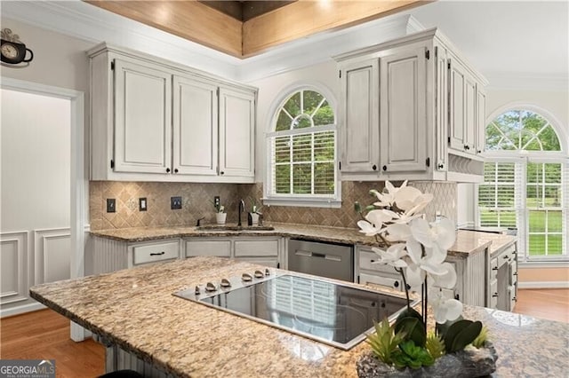 kitchen featuring tasteful backsplash, ornamental molding, stainless steel dishwasher, electric stovetop, and a sink