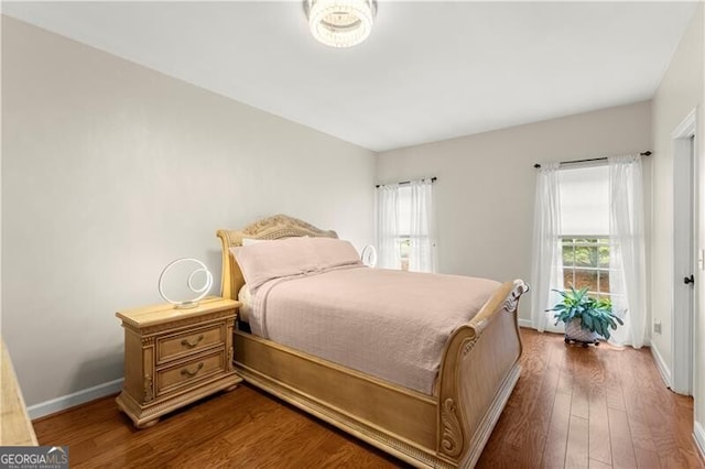bedroom with dark wood-style flooring and baseboards