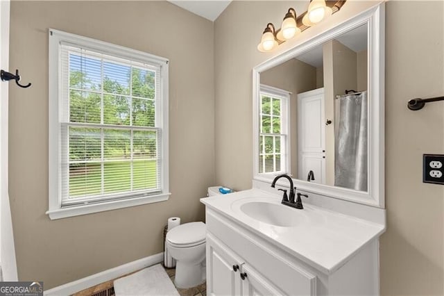 full bath featuring toilet, a shower with curtain, baseboards, and vanity