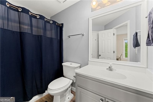 bathroom featuring curtained shower, vanity, and toilet