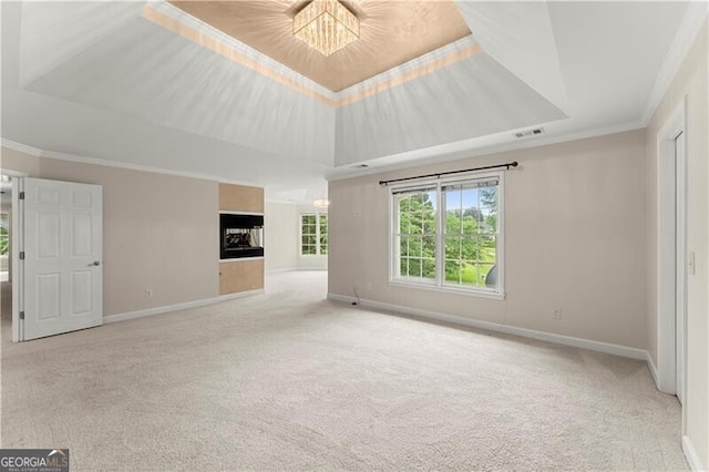 unfurnished living room featuring ornamental molding, carpet, a raised ceiling, and visible vents