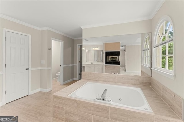 full bathroom with ornamental molding, baseboards, toilet, and a whirlpool tub