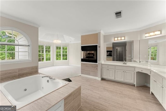 bathroom with ornamental molding, visible vents, a jetted tub, and vanity
