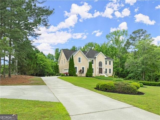 colonial home with a front yard, driveway, and stucco siding