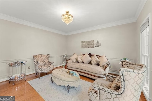 living room with ornamental molding, a decorative wall, and wood finished floors