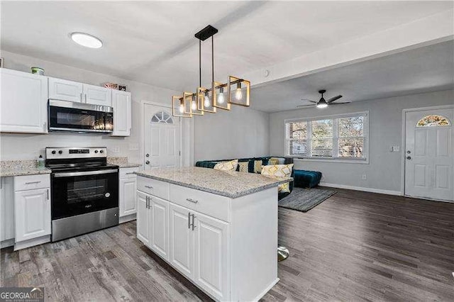 kitchen with appliances with stainless steel finishes, white cabinets, and dark wood-type flooring