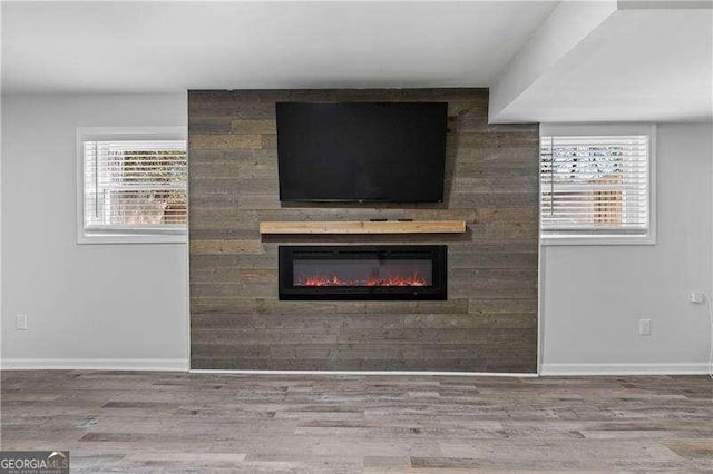 interior details featuring a fireplace, baseboards, and wood finished floors