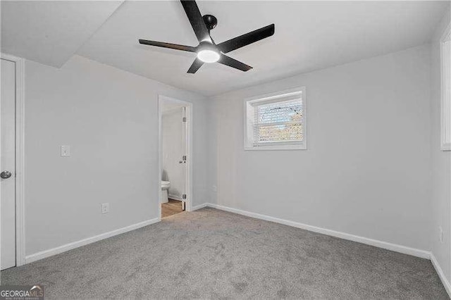 unfurnished bedroom with carpet floors, ceiling fan, baseboards, and ensuite bathroom