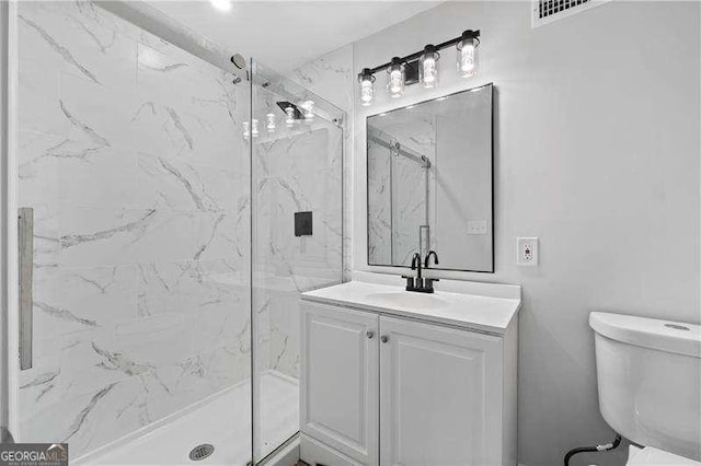 full bathroom with visible vents, vanity, a marble finish shower, and toilet