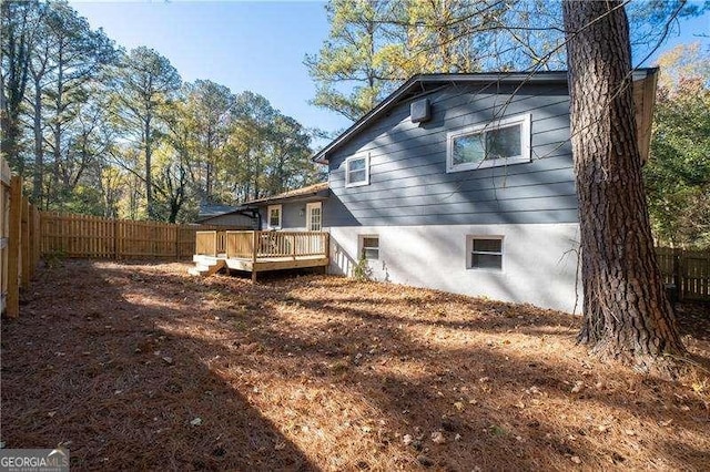 back of property featuring a fenced backyard and a wooden deck