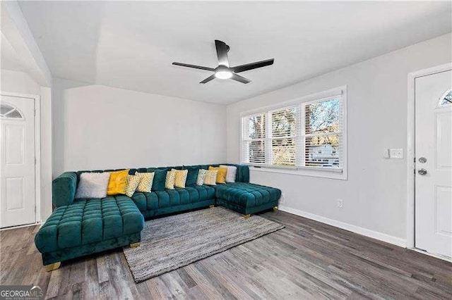 living room with ceiling fan, baseboards, and wood finished floors