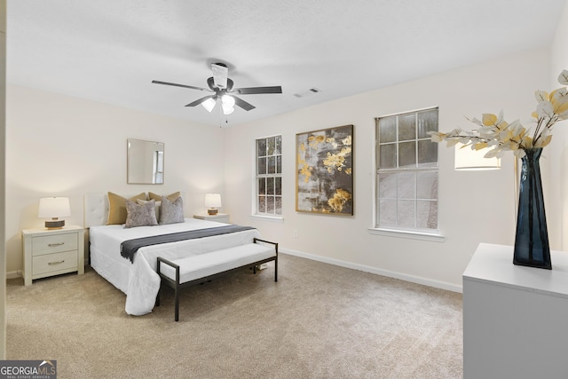 bedroom with visible vents, ceiling fan, light carpet, and baseboards