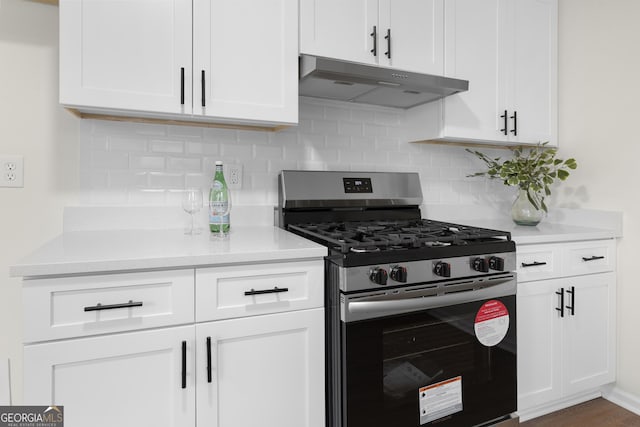 kitchen featuring light countertops, gas stove, white cabinets, and under cabinet range hood