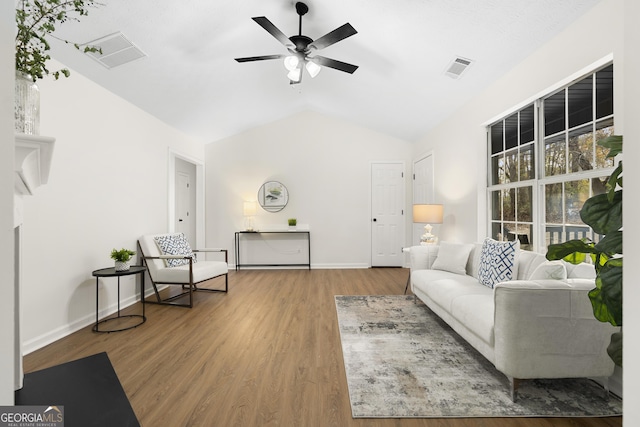 living room with lofted ceiling, a ceiling fan, visible vents, and wood finished floors