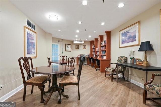 dining area with light wood finished floors, recessed lighting, visible vents, a wall mounted AC, and baseboards
