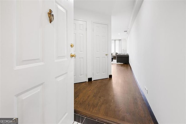 hall featuring baseboards and wood finished floors