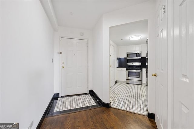 hall featuring baseboards and wood finished floors