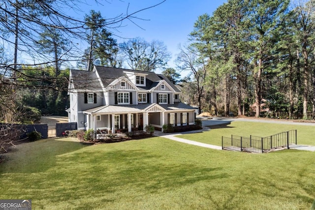 view of front of house featuring a gate, fence, a porch, and a front yard