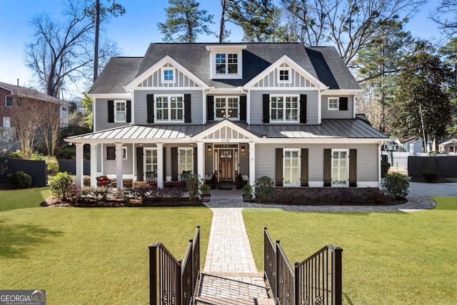 view of front of house with a front lawn, a standing seam roof, and fence private yard