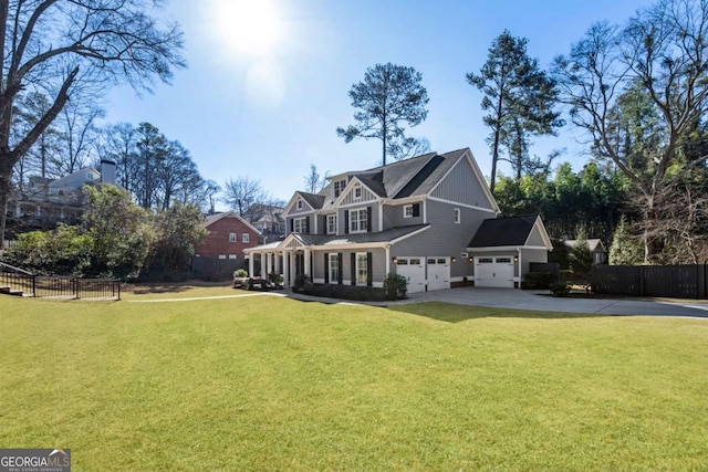 back of house featuring driveway, a garage, fence, and a lawn