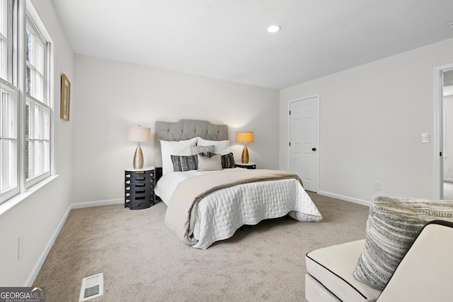 carpeted bedroom with multiple windows, visible vents, and baseboards