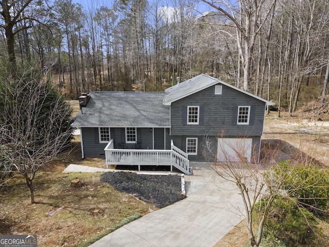 split level home with a garage, driveway, and a deck