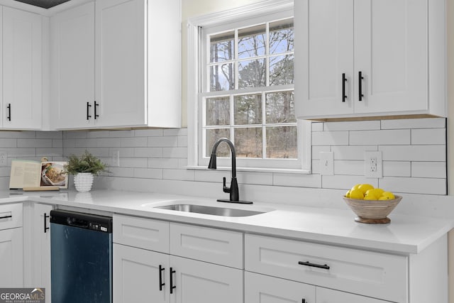 kitchen with a sink, a wealth of natural light, light countertops, and dishwasher