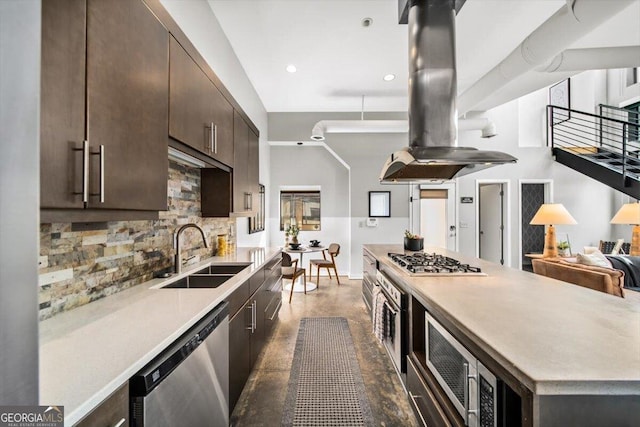 kitchen with dark brown cabinetry, island range hood, a sink, appliances with stainless steel finishes, and backsplash