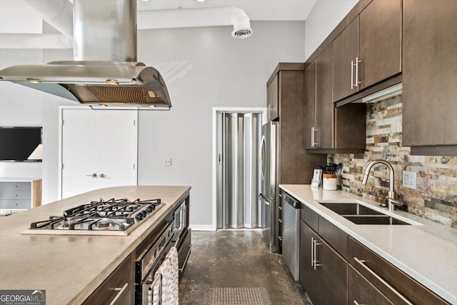 kitchen featuring dark brown cabinetry, island range hood, appliances with stainless steel finishes, a sink, and backsplash