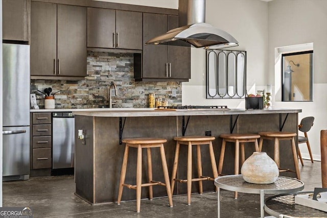 kitchen with a kitchen breakfast bar, backsplash, freestanding refrigerator, and island range hood