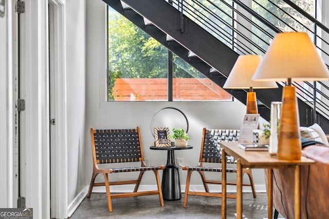 living area featuring baseboards and finished concrete floors