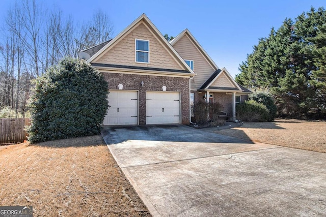 view of front of house with driveway, a garage, fence, and brick siding