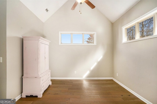 interior space featuring baseboards, visible vents, vaulted ceiling, and hardwood / wood-style floors