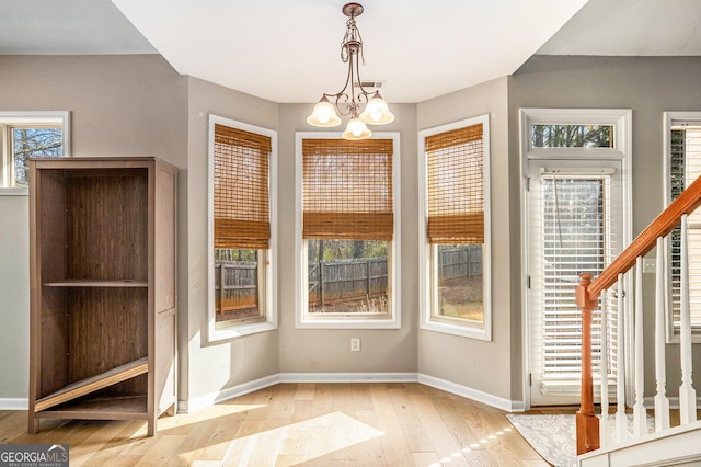 8000 Abington Dr, Locust Grove, GA 30248 - unfurnished dining area featuring wood-type flooring, baseboards, and a chandelier