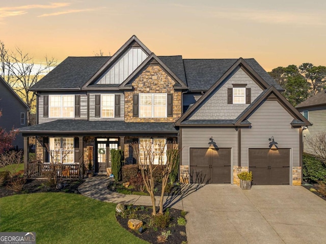 craftsman-style home featuring stone siding, a porch, board and batten siding, and a front lawn