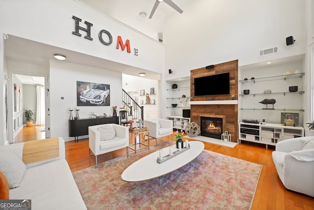 living room featuring a fireplace, wood finished floors, visible vents, and built in features