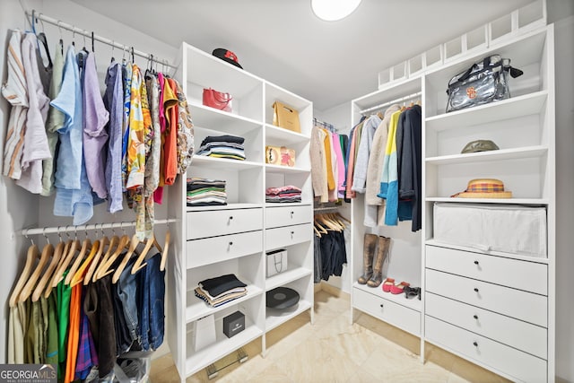 walk in closet featuring marble finish floor